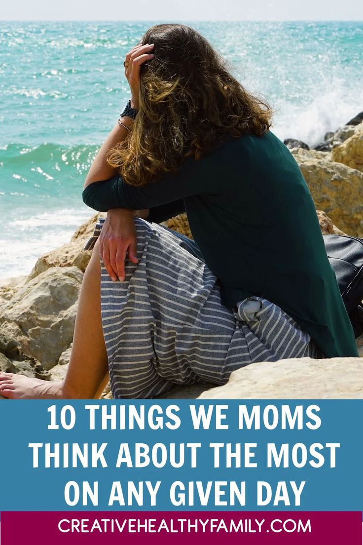 a woman sitting on rocks with the ocean in the background and text overlay that reads 10 things we moms think about the most on any given day