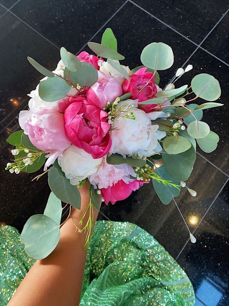 a woman holding a bouquet of flowers on top of her head in front of a tiled floor