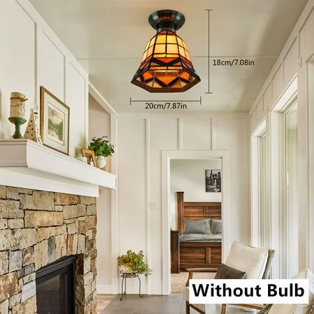 a living room filled with furniture and a fire place next to a fireplace under a stained glass light