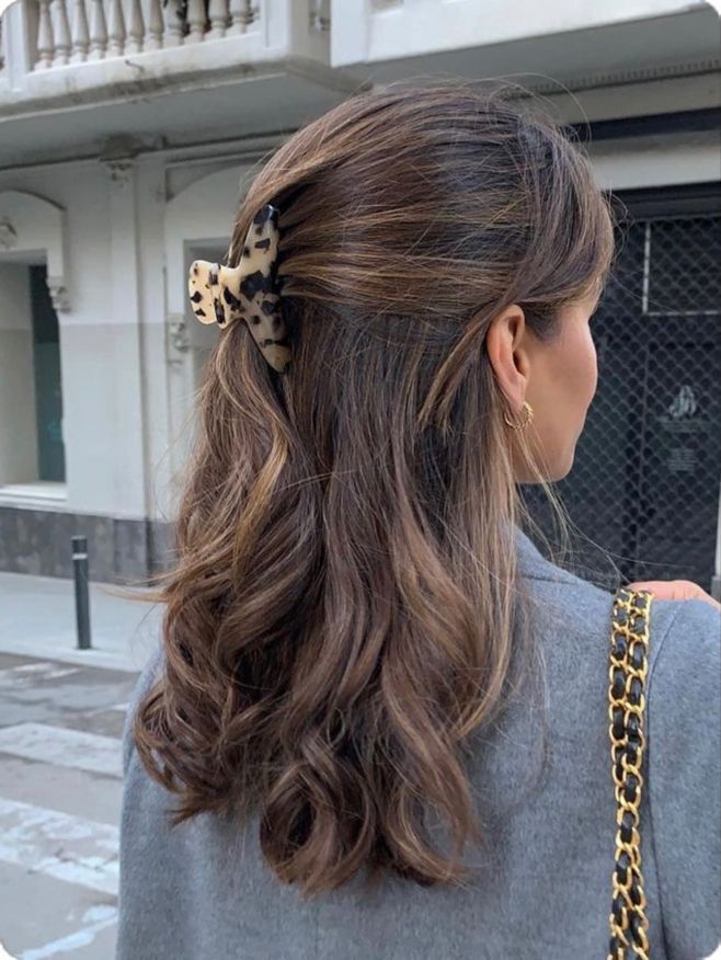 a woman with long hair and a leopard print bow in her hair is standing on the street