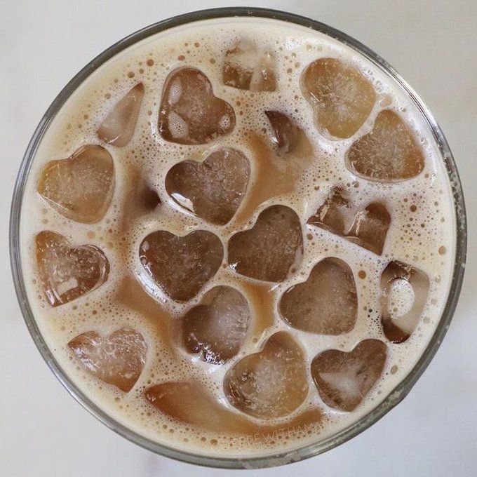 a glass filled with liquid and lots of hearts