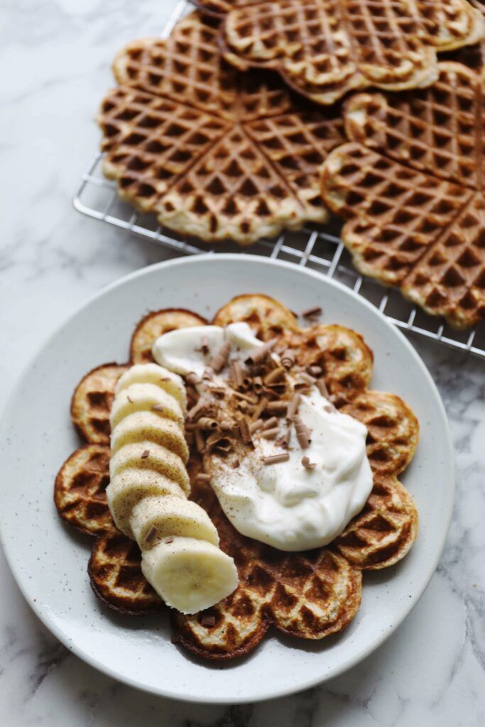 some waffles and bananas on a white plate