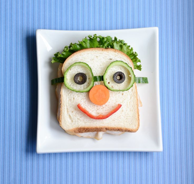 a sandwich made to look like a face with cucumbers and eyes on it