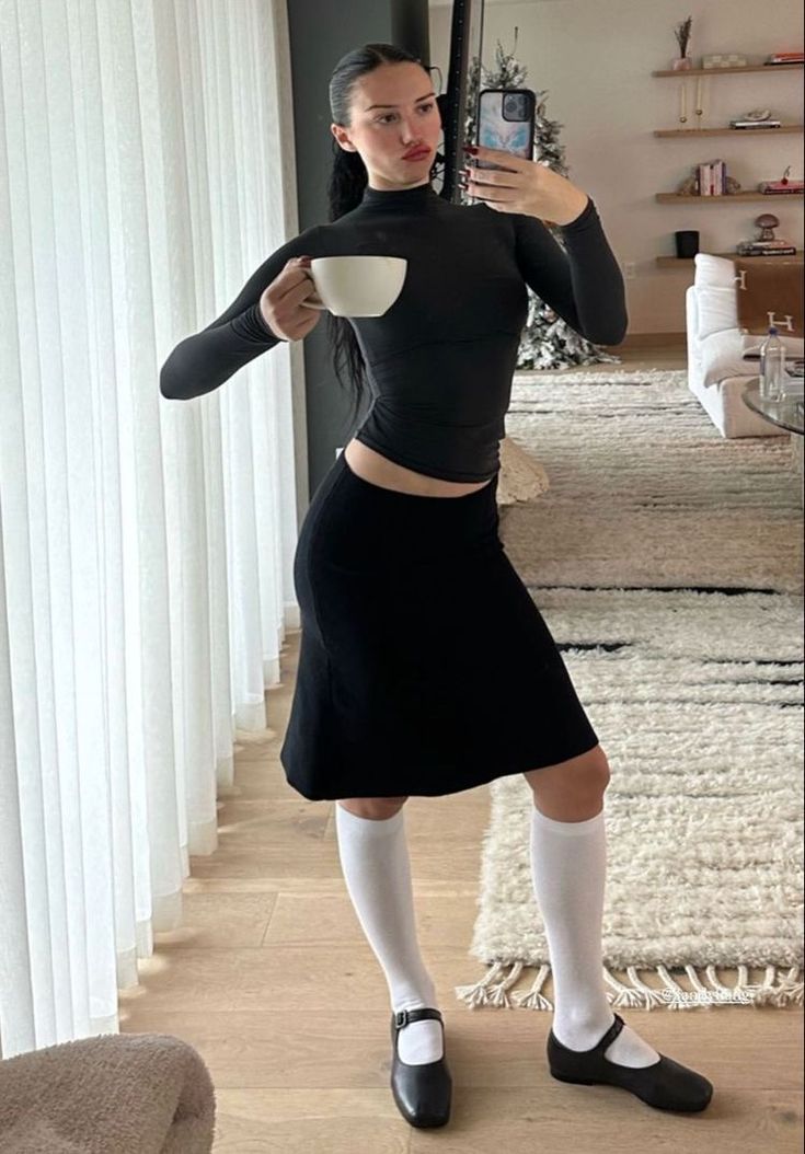 a woman is taking a selfie with her cell phone while wearing a skirt and socks