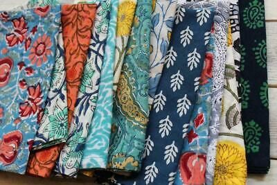 a bunch of different types of cloths on a table with white wood boards in the background