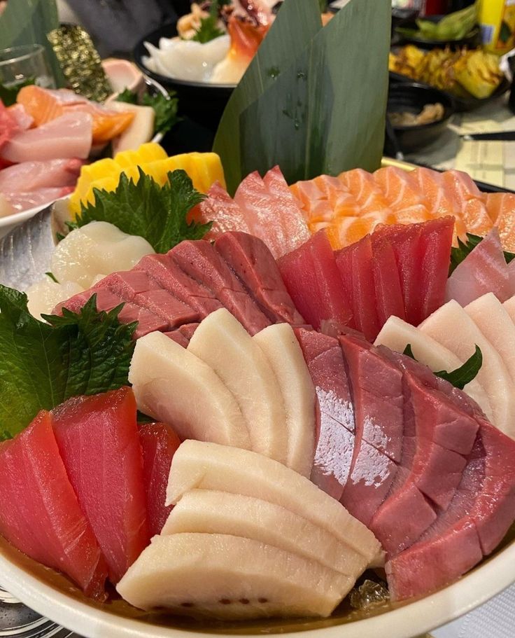 there are many different types of sashimi on the platter, including tuna and other meats