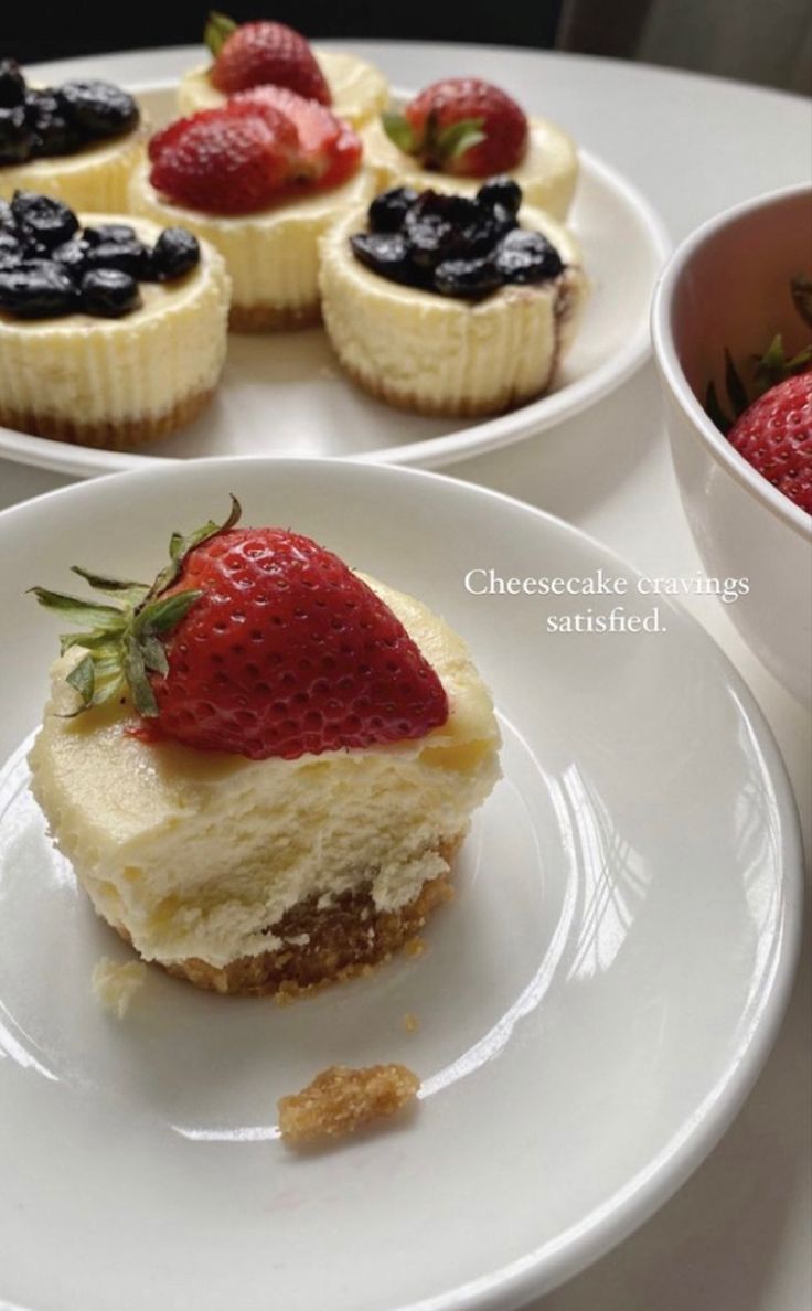 three small desserts on plates with strawberries and blueberries