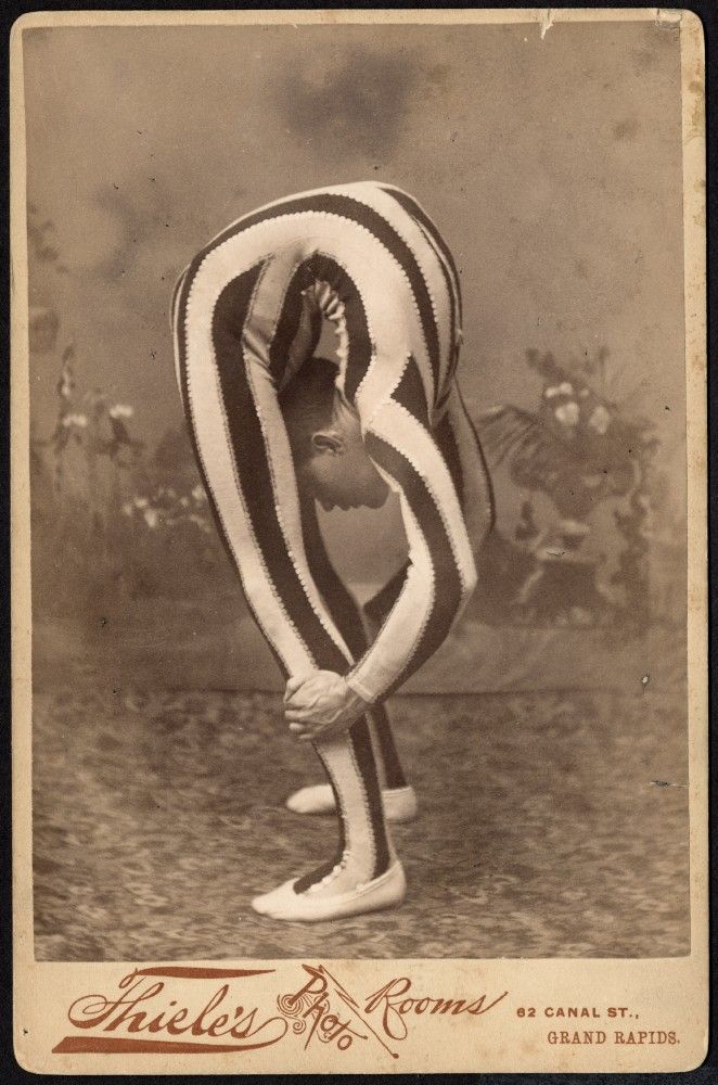 an old time photo of a man in striped clothing with his hands on his hips