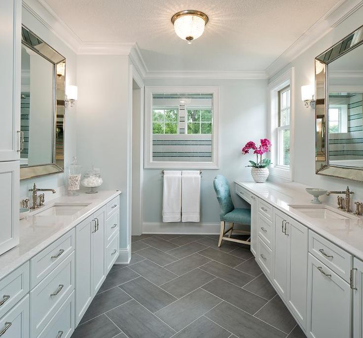 a large bathroom with two sinks and mirrors on the wall, along with white cabinets