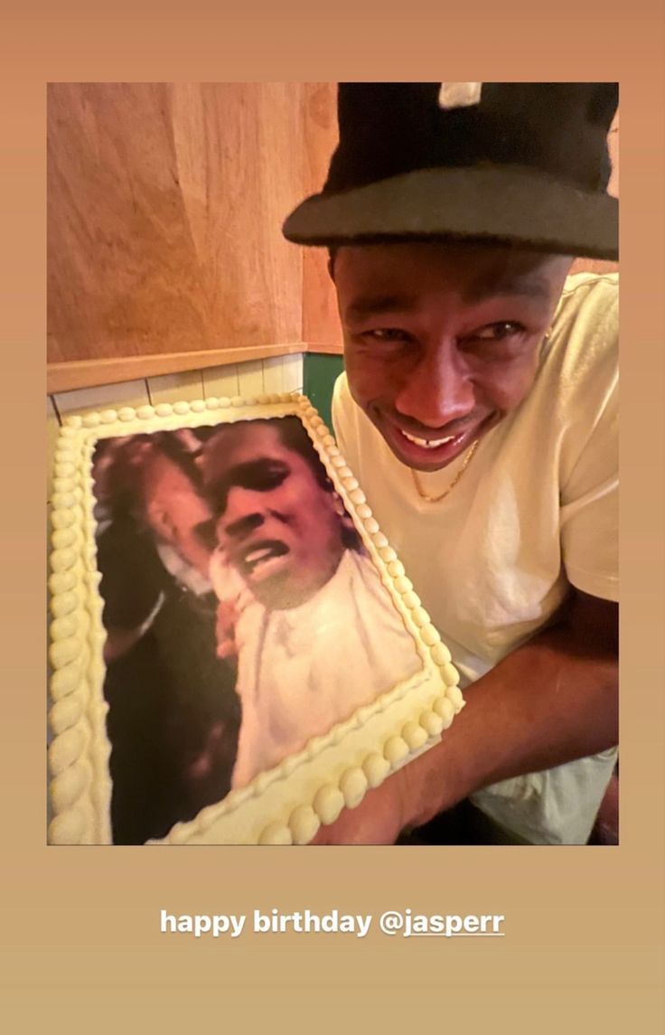 a man holding up a cake with a photo on it