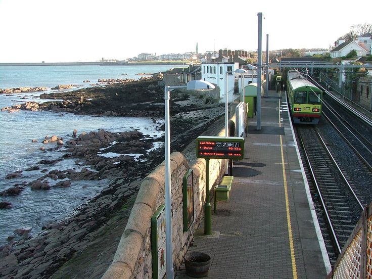 a train traveling down tracks next to the ocean