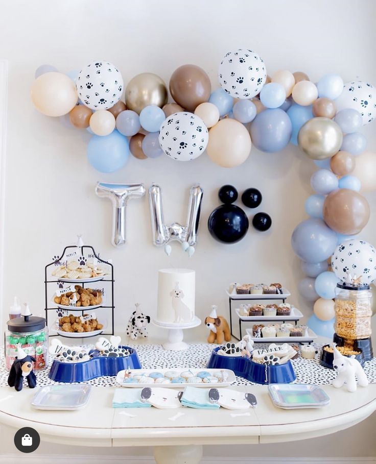 a table topped with lots of balloons and desserts