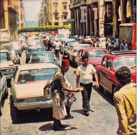 an old photo of people and cars on a busy street in the 1950's