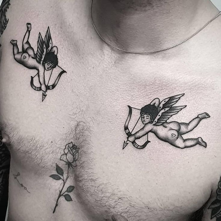 a man with tattoos on his chest is holding a rose and cupid angel tattoo