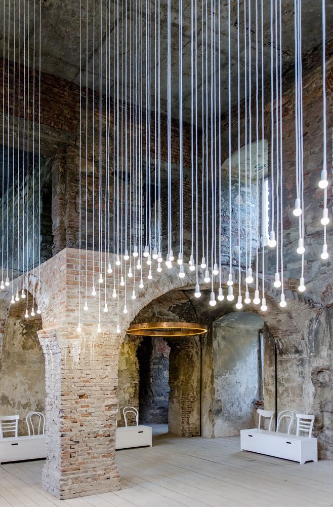 a room with several chairs and chandeliers hanging from the ceiling