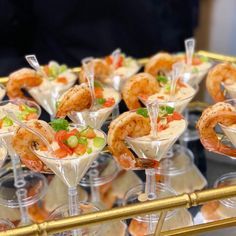 there are many small cups with food in them on the tray and one is filled with shrimp