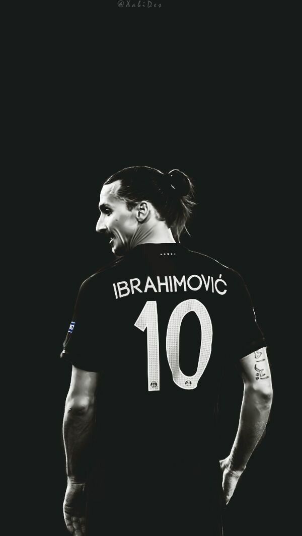 a man with his mouth open standing in front of a black background wearing a soccer jersey