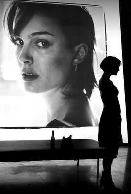 a person standing in front of a large screen with a woman's face on it