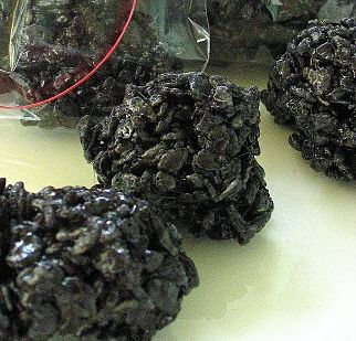 several pieces of black rock sitting on top of a white table next to a glass vase