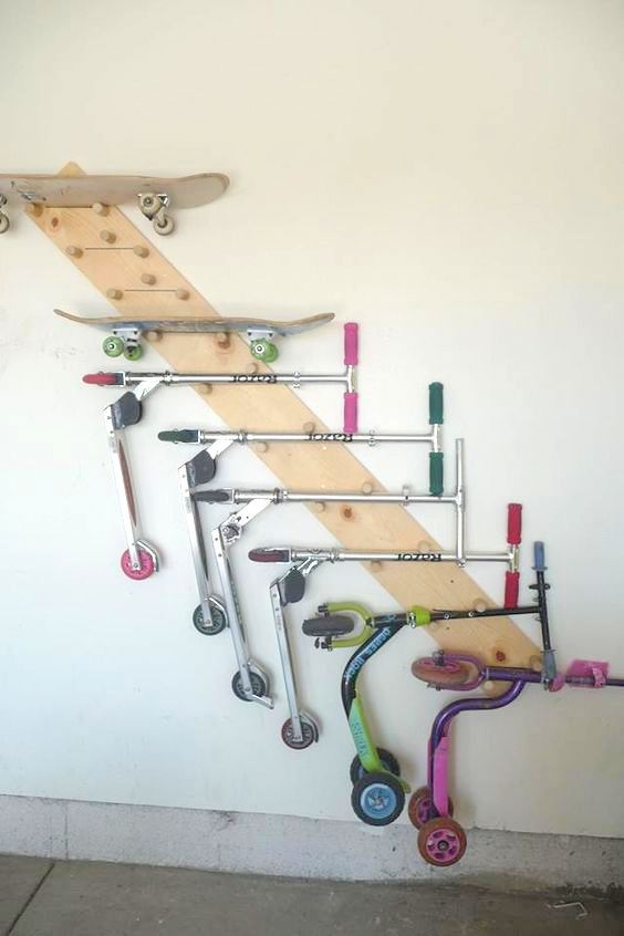 there is a skateboard rack on the wall with many different things attached to it