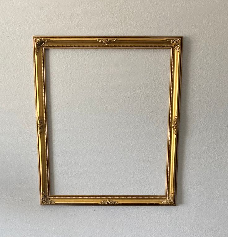 an empty gold frame hanging on the wall