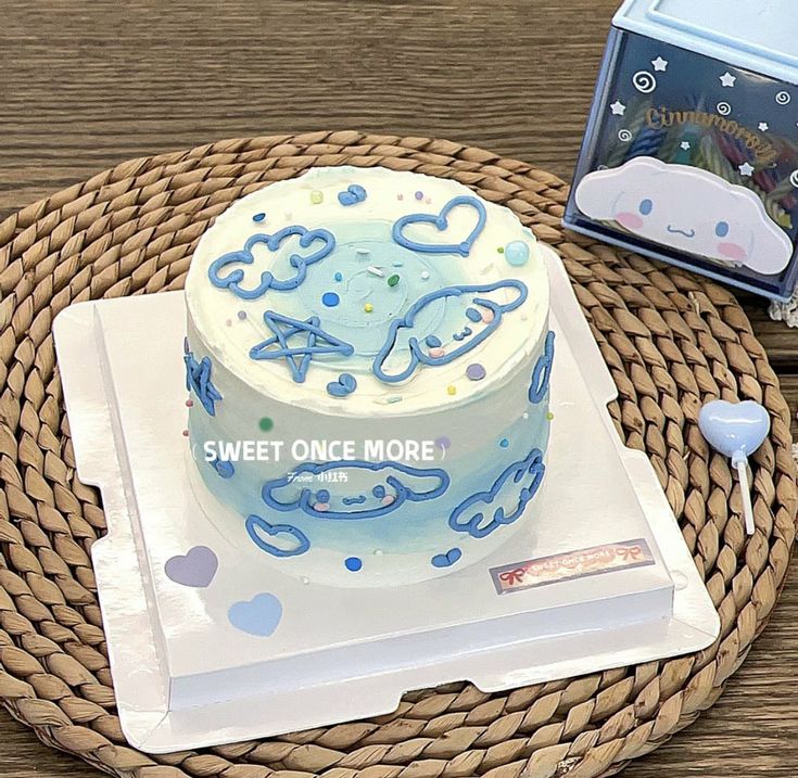 a blue and white cake sitting on top of a table next to a card box