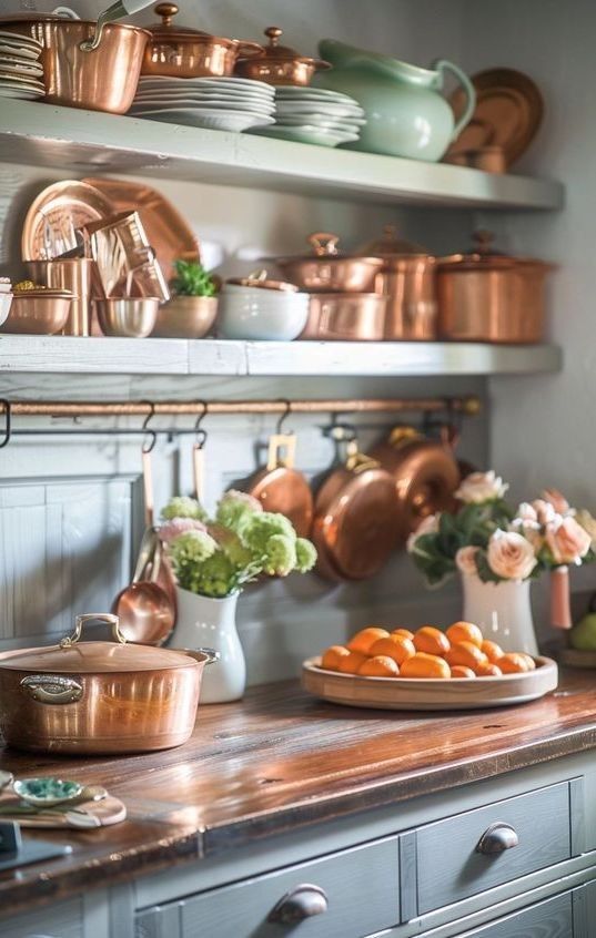 copper pots and pans are on the shelves in this kitchen, along with other cooking utensils