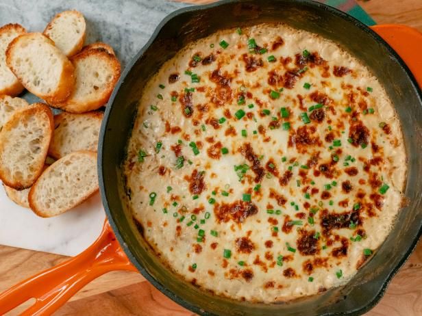 a pan filled with food next to slices of bread