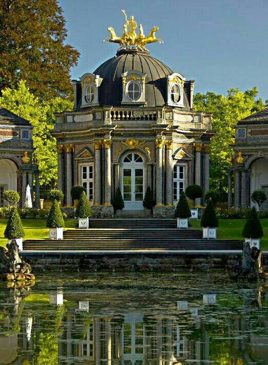 a large building with a pond in front of it