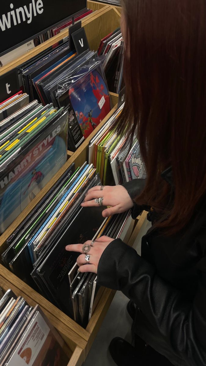 a woman looking at records in a record store