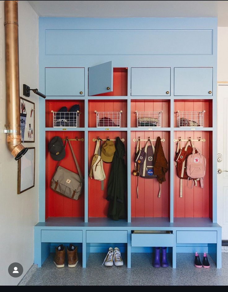 an entryway with blue and red cubbys filled with purses, shoes and handbags