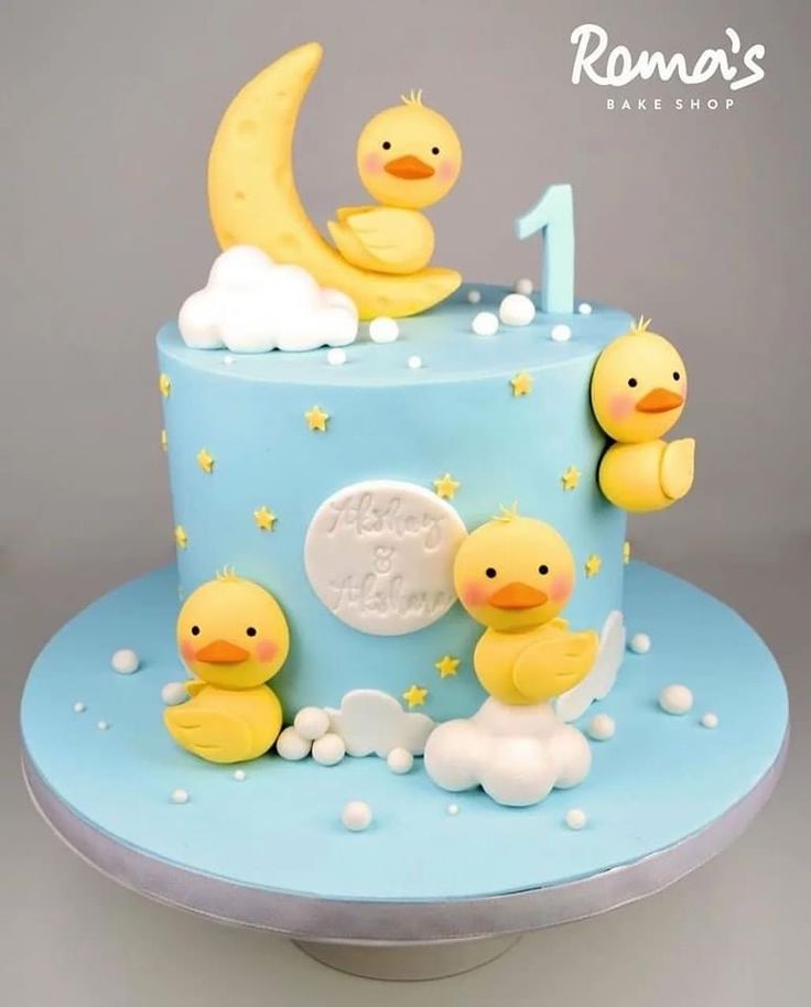 a blue cake with yellow rubber ducks on it and the number one in the middle