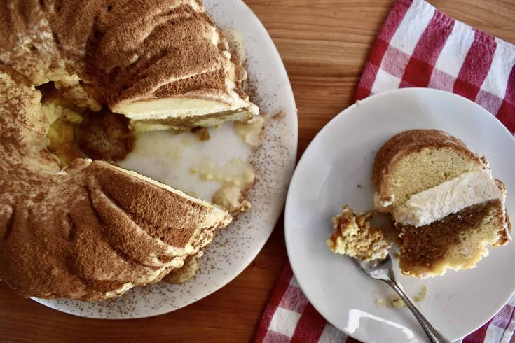 a bundt cake on a white plate with a slice taken out of it and a red checkered napkin