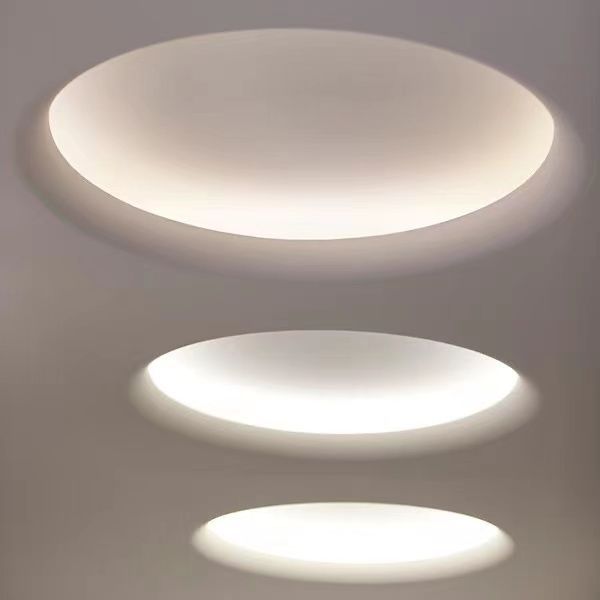 three circular lights are hanging from the ceiling in an empty room with white walls and flooring