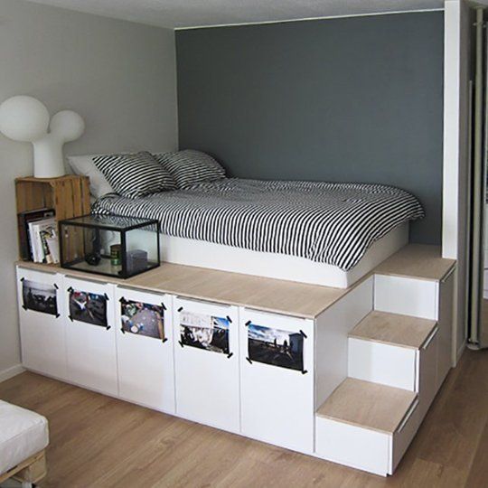 there is a bed that has been built into the side of a shelf with pictures on it