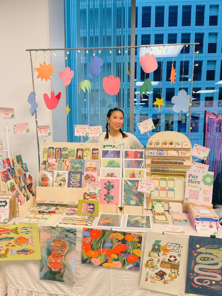 a woman standing next to a table full of greeting cards