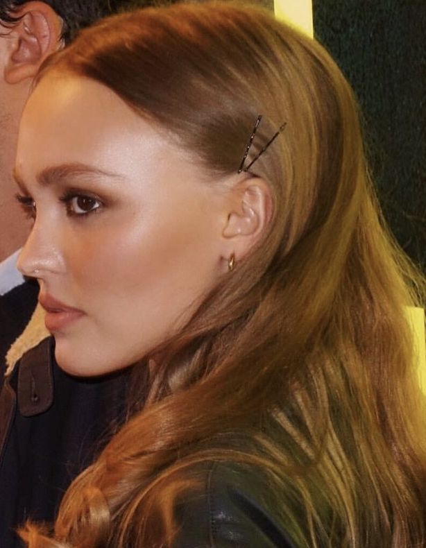 a woman with long hair and piercings sitting next to a man in a black jacket