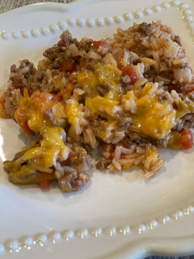 a white plate topped with rice and meat