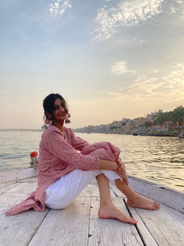 a woman sitting on the end of a boat