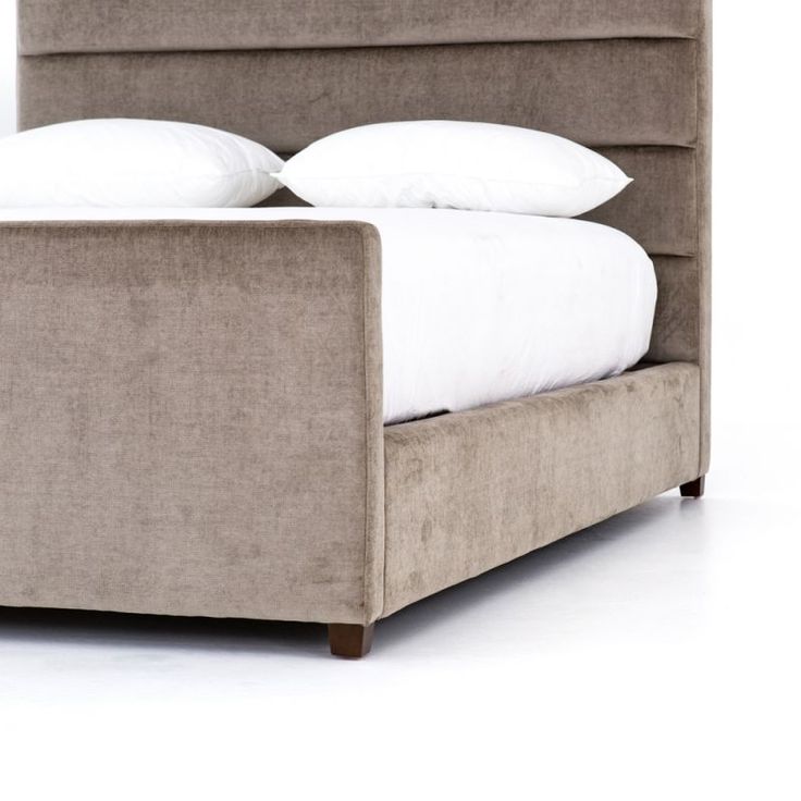 an upholstered bed frame with white pillows