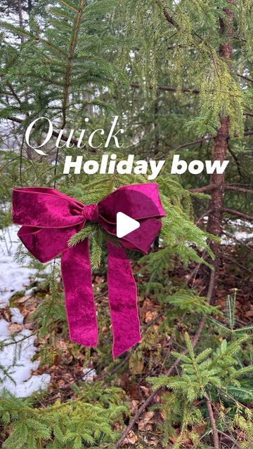 a pink bow hanging from the side of a tree