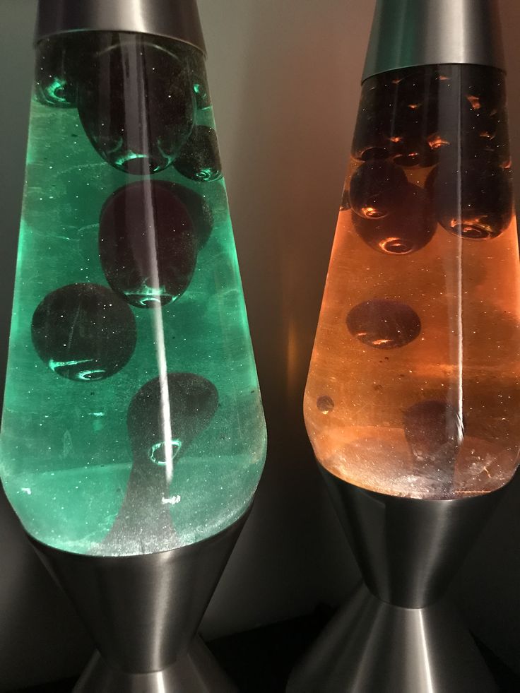 two glass vases with different colored liquids in them