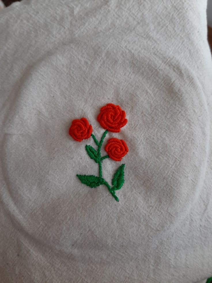 a white towel with red flowers embroidered on it