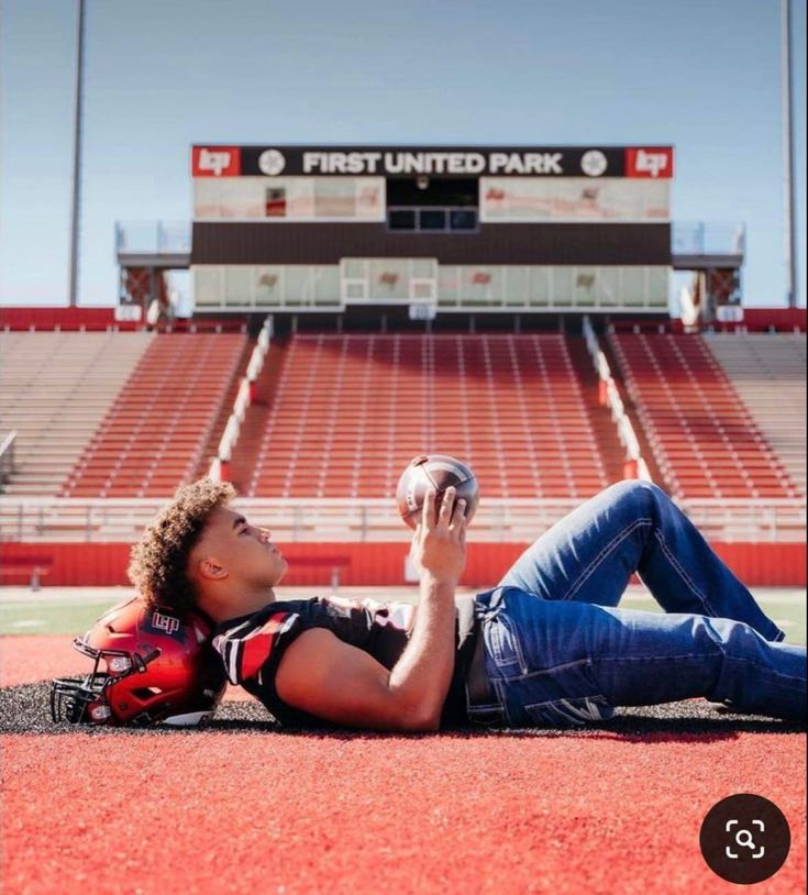 a man laying on the ground holding a football