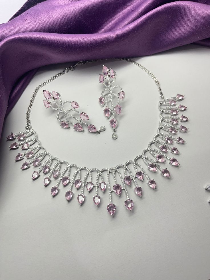 Gorgeous fine quality replica diamond and transparent Pink  CZ stones studded necklace with a white gold rhodium plating and matching Earrings Item contains: Necklace and earrings AAA-quality cubic zirconia was used. Highest quality and craftsmanship Necklace Fitting is adjustable Earrings Closure: Pushback Necklace Closure: chain with Hook Glamorous Cubic Zirconia Jewelry With Diamond Cut, Costume Jewelry With Hand-set Cubic Zirconia, Fine Jewelry Cubic Zirconia Bridal Necklace For Party, Costume Jewelry With Sparkling Cubic Zirconia Stones, Party Jewelry Sets With Brilliant Cut Crystal, White Gold Jewelry Sets With Diamond Accents And Crystal, Glamorous Prong Setting Jewelry For Party, Glamorous Cubic Zirconia Jewelry With Hand Set, Glamorous White Gold Cubic Zirconia Jewelry