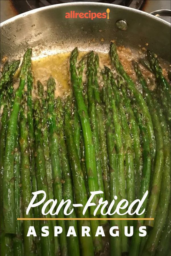 asparagus being cooked in a pan on the stove with oil and seasoning