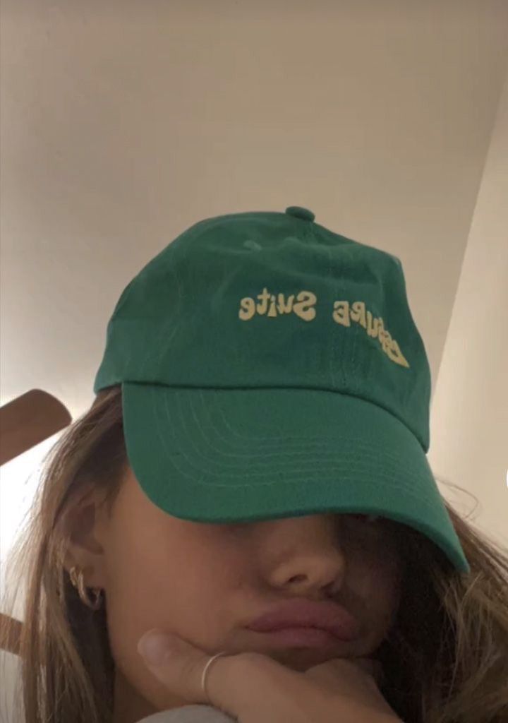 a woman wearing a green hat with the words bubba suite on it