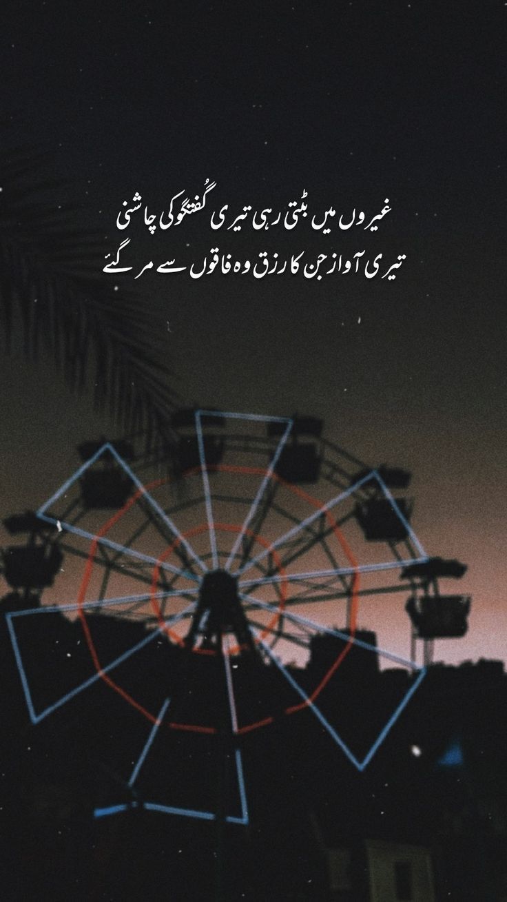 the ferris wheel is lit up at night with an arabic quote in front of it