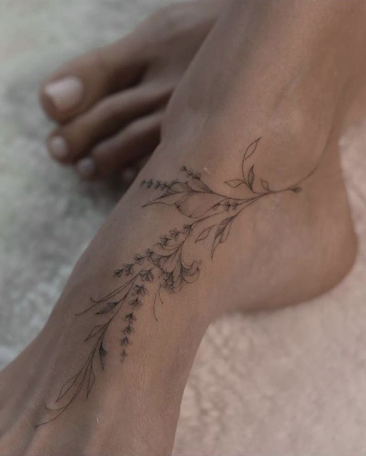 a woman's foot with a flower tattoo on her left side and the bottom part of her leg