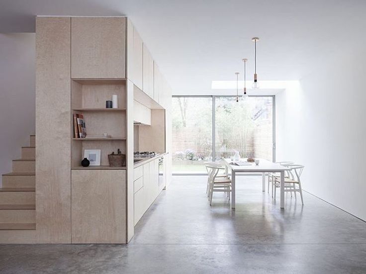 an open kitchen and dining room with stairs leading up to the upper floor